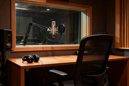 Cabine de doublage vide, micro suspendu et casque posé sur la table dans un studio d'enregistrement