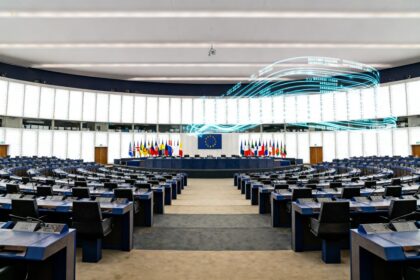 Grande salle d'assemblée internationale vide, rangées de pupitres et drapeaux nationaux
