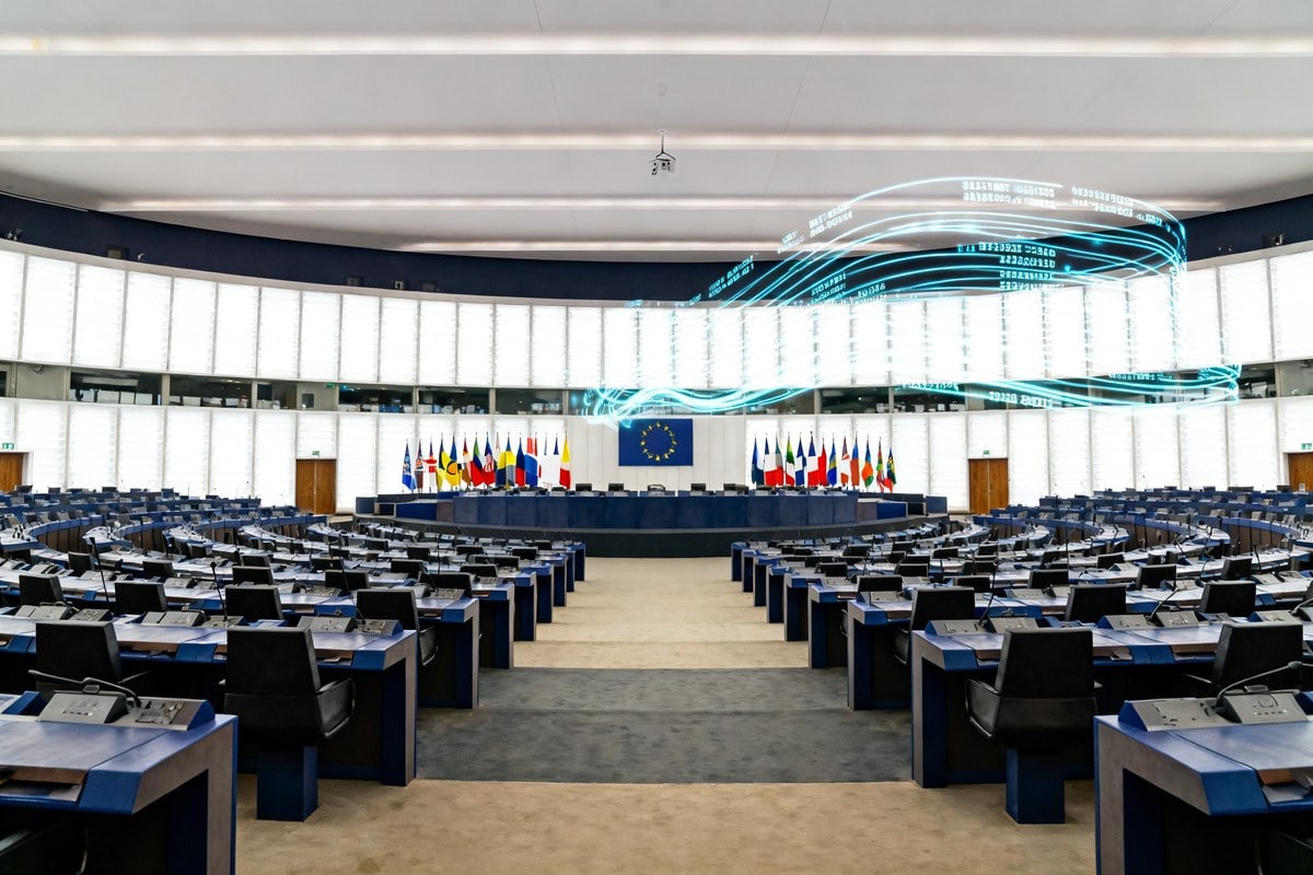 Grande salle d'assemblée internationale vide, rangées de pupitres et drapeaux nationaux
